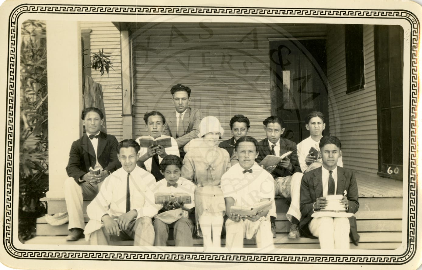 Bible class on the porch: boys with open books around two women.