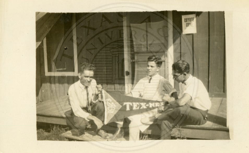 Three students on a porch with the ‘Tex Mex 1923’ banner.