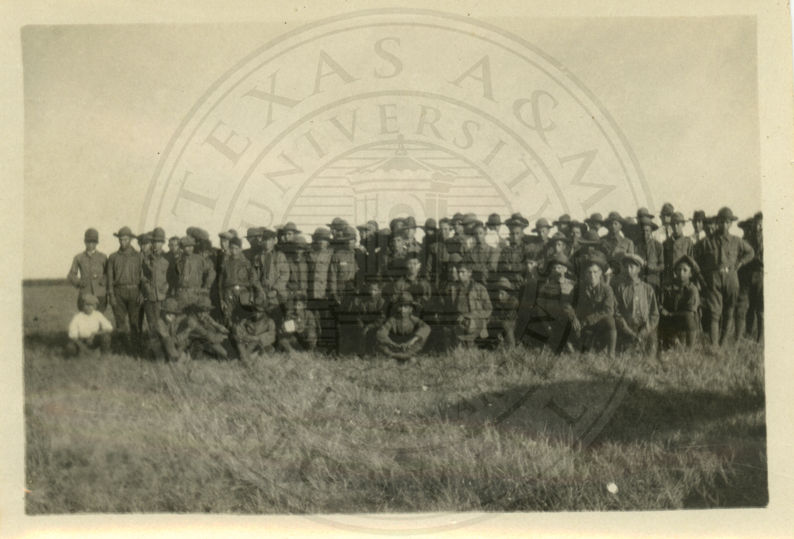 Men and boys of the school in a field, posed for a group picture.