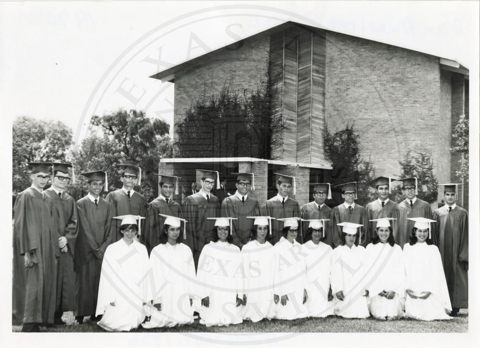Graduates in white outside the chapel.