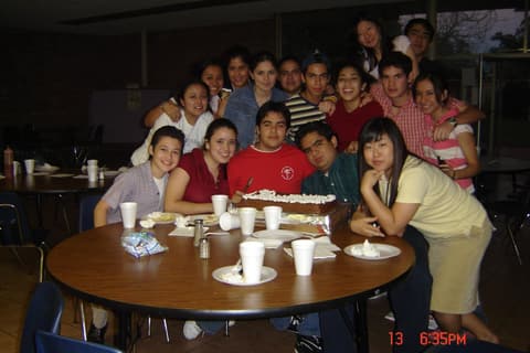 Friends gathered around a table with cake, shared in memory of their classmate Jose Carlos Guerrero Garcia.