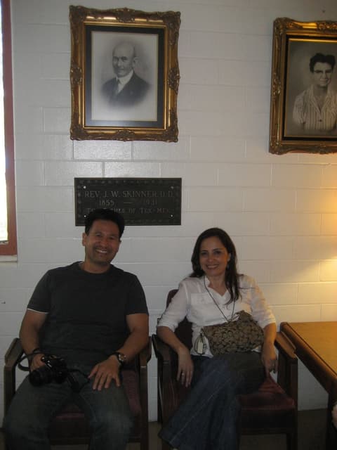 Two alumni in the office under portraits of the school’s early leaders, 2012.