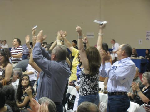 Alumni cheer when their decade is called at the Centennial program in the gym.