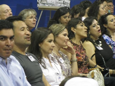 Alumni singing along at the Centennial program in the gym.
