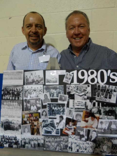 Two alumni with the 1980s history board at the Centennial.