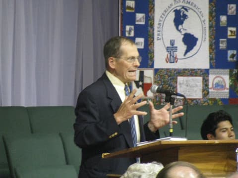 Mr. Gifford speaks at the Centennial program before the anniversary quilt.