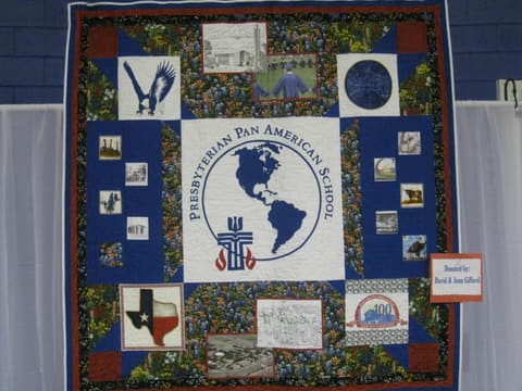 The Centennial quilt, donated by David and Joan Gifford, with the school seal, the eagle and scenes of campus.