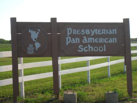 The wooden school sign by the white fence, 2012.
