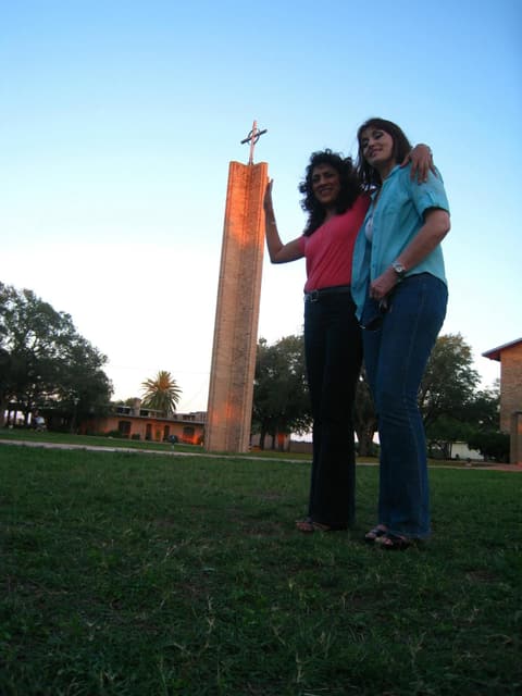 Two alumnae at the foot of the chapel tower — “we grew so much the tower looks small”.