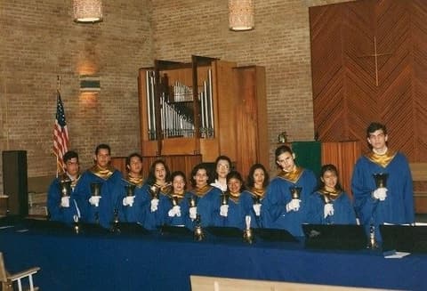 The handbell choir in the chapel before the Rieger pipe organ, built in Austria; George Partida and Damaris Sandoval are among the ringers.