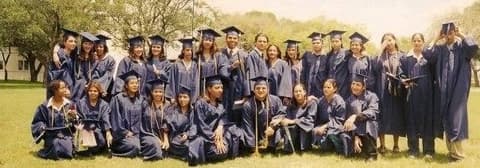The Class of 1999 in caps and gowns on the lawn.