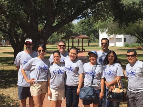 The Class of 1996 in reunion T-shirts under the oaks.