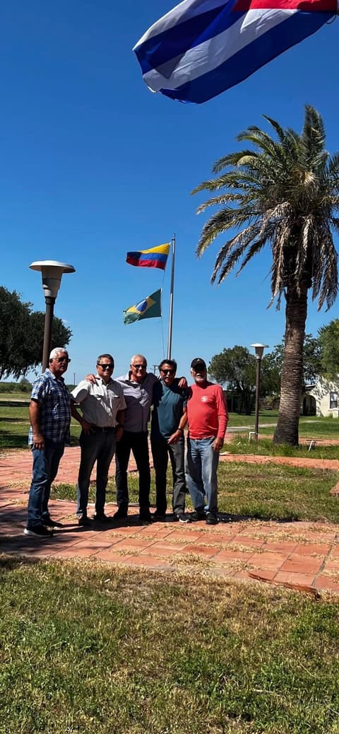 The Cuban classmates under the flagpoles, the Cuban flag flying, during their campus visit.