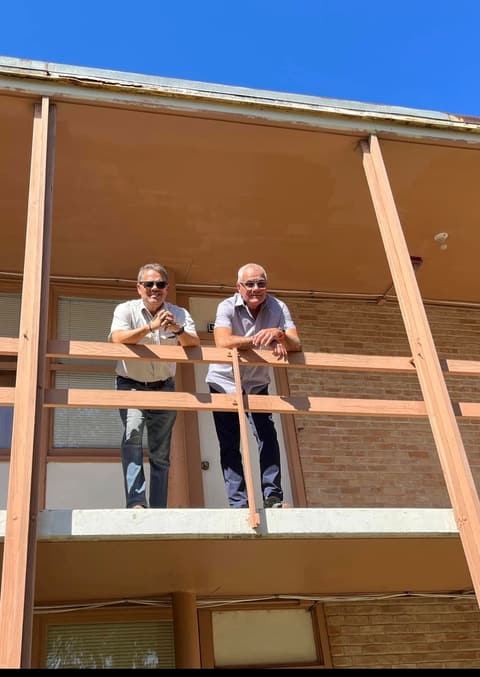 Two of the Cuban classmates of the early 1970s on a dorm balcony during their visit.