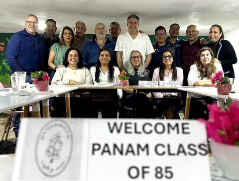The Class of 1985 at its 40th-anniversary reunion dinner, behind a “Welcome Panam Class of 85” sign.