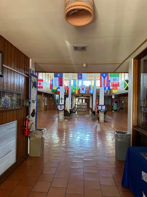 A hallway hung with the flags of students’ home countries; alumni say they wish the flags had been there in their day.
