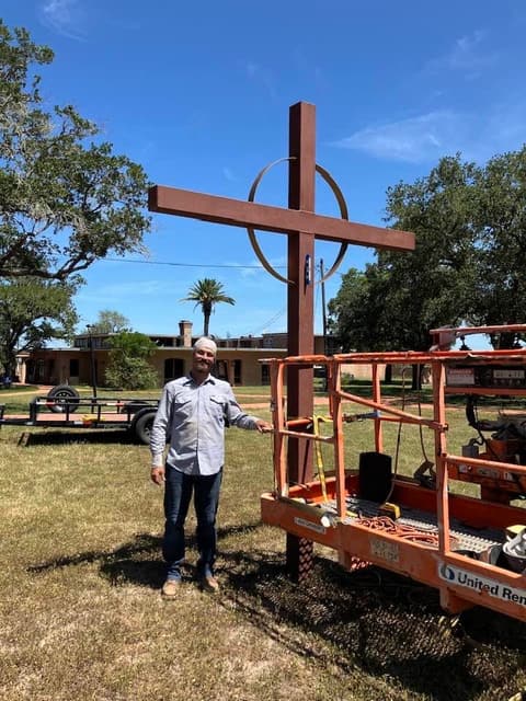The new cross, ready to be raised to the top of the chapel tower.