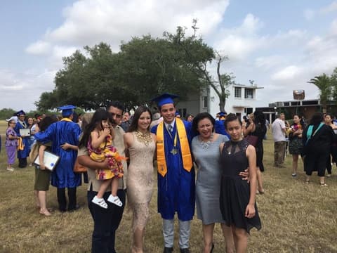 A graduate with his family on the lawn after the ceremony.