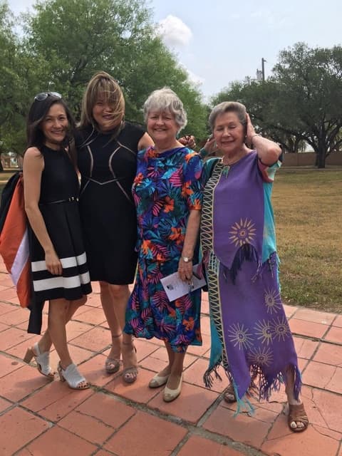 Teachers and guests on the walkway after graduation.
