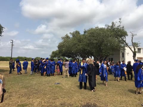 Graduates and families mingling on the lawn after the ceremony.