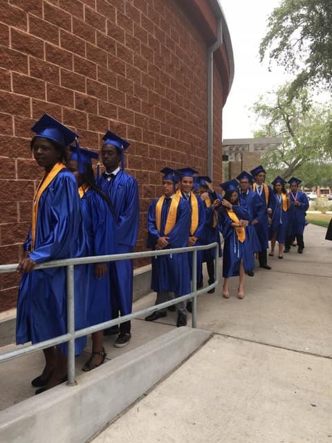 Graduates filing along the gym wall before the procession.