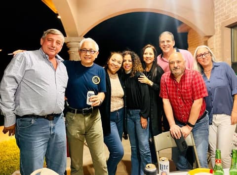Alumni together on the patio at night during the reunion.
