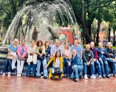 Alumni of the mid-1980s by the coyote fountain in Coyoacán during a Mexico City reunion.