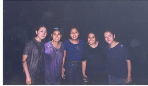 Five friends at night, soaked through after a water fight.