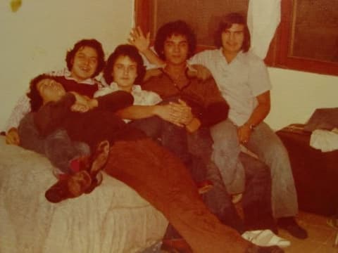 Boys piled on a bed in the dorm.