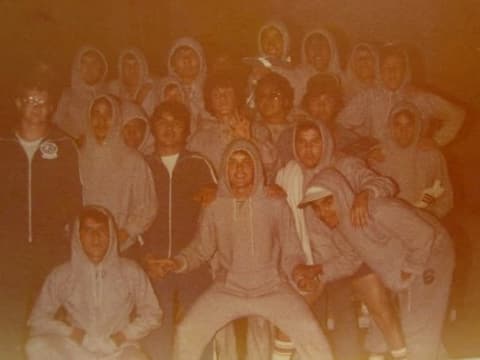 A crowd of boys in matching grey hooded sweatsuits.