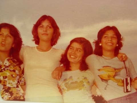 Four girls arm in arm, late 1970s.