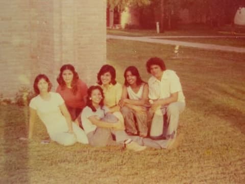 Friends sitting on the grass beside the chapel.