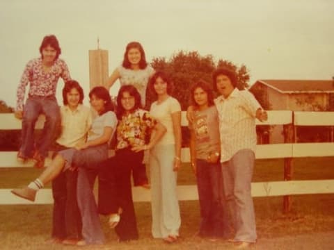 A group of friends on the white fence by the chapel tower.