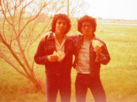 Two friends eating tortillas on the lawn — something new for the Brazilian student.