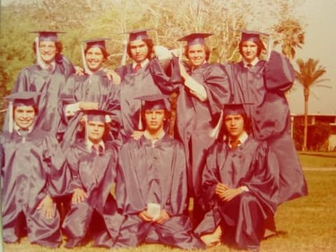 Senior boys of the Class of 1978 in caps and gowns under the palms.