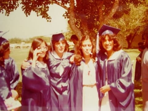 Graduates of 1981 clowning under a tree after the ceremony.