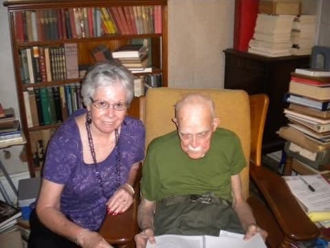 Mr. Perry Reed, the beloved history teacher, with Elma Flores-Cook on his birthday, surrounded by his books.