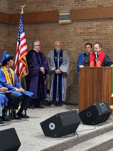 Faculty and pastors on stage at the Class of 2026 graduation.
