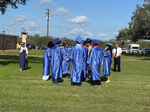 The Class of 2026 in its circle on the lawn after graduation.