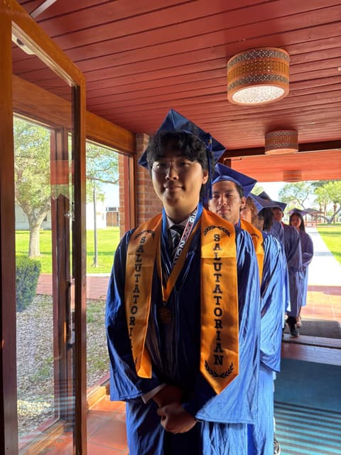 A Class of 2026 graduate in honor stoles files into Morris Chapel.