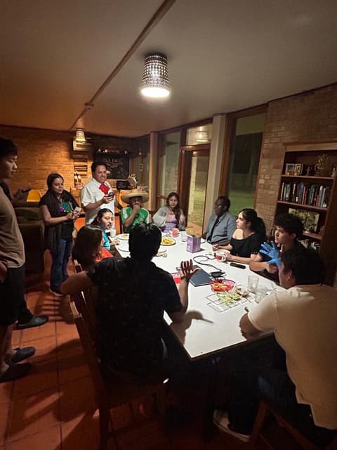 Students at a festive dinner night in the dorm lounge, with sombreros and a Mexican-flag spread, fall 2025.