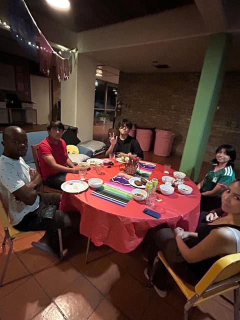Students at a festive dinner night in the dorm lounge, with sombreros and a Mexican-flag spread, fall 2025.