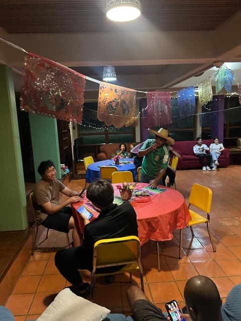 Students at a festive dinner night in the dorm lounge, with sombreros and a Mexican-flag spread, fall 2025.
