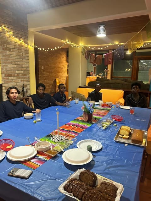 Students at a festive dinner night in the dorm lounge, with sombreros and a Mexican-flag spread, fall 2025.