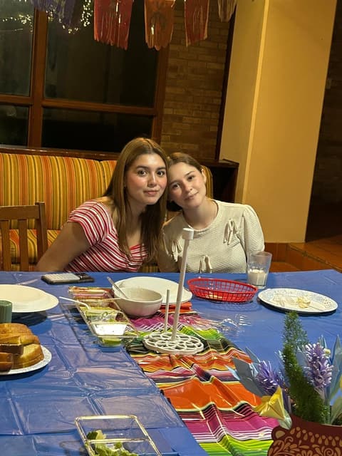 Students at a festive dinner night in the dorm lounge, with sombreros and a Mexican-flag spread, fall 2025.