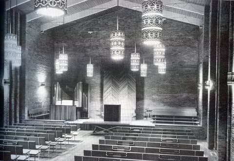 The chapel interior with its original pews, lantern lights and pipe organ.