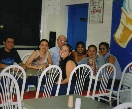 Students and an older teacher at a table in the snack bar.