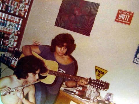 Guitar and flute practice in a dorm room decorated with road signs.