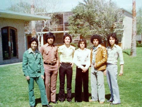 Six friends dressed up in front of the dorms.