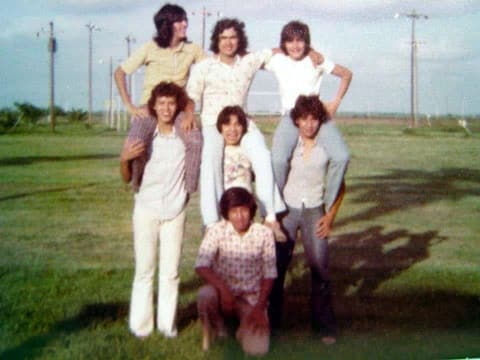 A human pyramid of friends on the lawn.